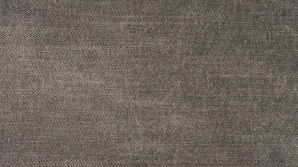 Fototapeta na wymiar Closeup of black jeans fabric with texture and rough surface in black and white or gray vintage tone for background and decoration. Textile texture concept and cool banner on page and cover