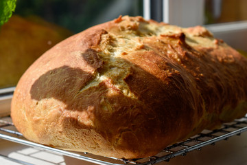 A home baked loaf of bread cooling by a window