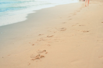 foot print on sand beach with soft focus beach background on summer season