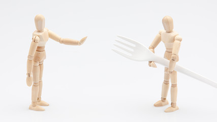 Wooden dummy refusing to help his friend to carry a biodegradable fork in front of a white...