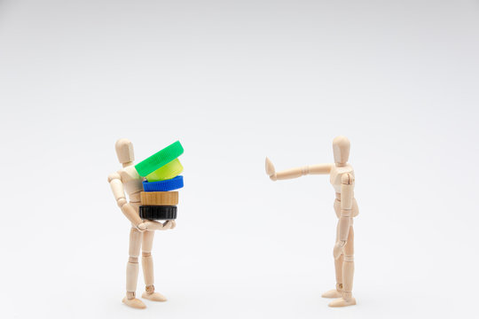 Wooden dummy refusing plastic plugs in front of a white background