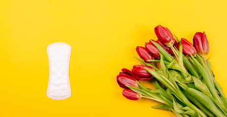 Top view of women's sanitary pads, panty liners on a yellow background. Flat lay.
