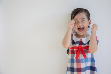 A cute four-year-old asian girl is smiling and acting with the camera. Anyone who sees will feel bright and happy. Photos in the studio on a white background for half body shot with copy space.