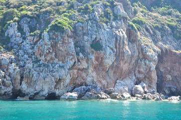 The rock rises above the turquoise surface of the sea.