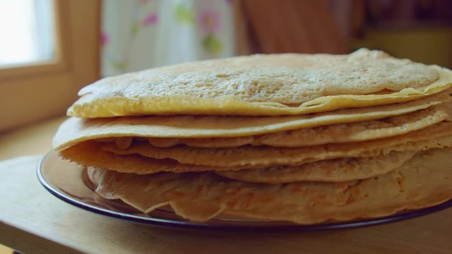 Yummy yellow pancake stack on glass plate. Home cooking steam. Slowmo closeup.