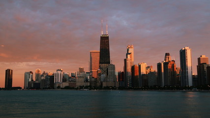 Fototapeta na wymiar Chicago skyline across Lake Michigan at sunset viewed from North Avenue Beach. Long exposure.