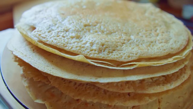 Zoom on yellow delicious pancake stack on glass plate. Slowmo. Side view.