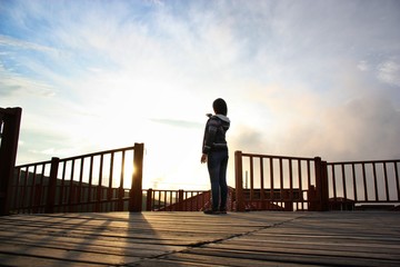 chica mirando el atardecer señalando el sol 