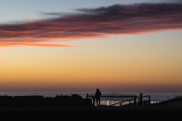 Silhouette de femme regardant le coucher de soleil