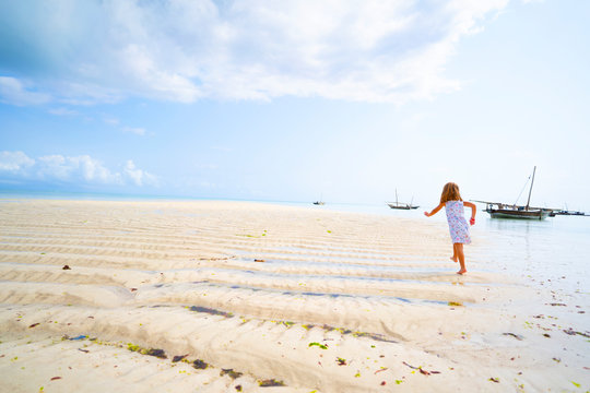 Ni&ntilde;a corriendo en la playa