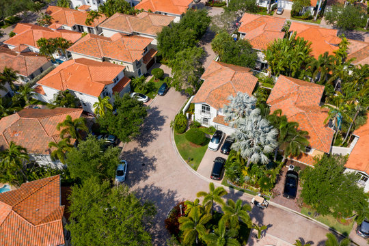 Aerial photo upscale Miami neighborhood with palm trees and cars in driveway