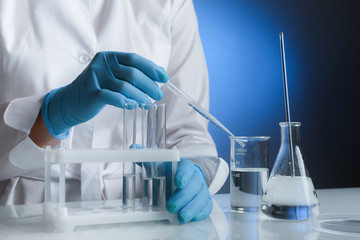 Fototapeta premium production of vaccine against virus . scientist's hands in gloves are conducting chemical experiments in lab. chemist works with lab glassware close up