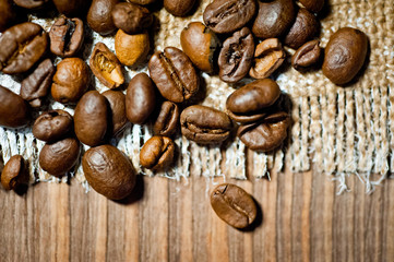 Grains of black coffee lying on a rough canvas. Background for coffee drinks.