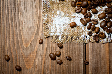 Grains of black coffee lying on a rough canvas. Background for coffee drinks.