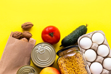 Canned goods, walnuts, fresh vegetables, tomato and cucumber, chichen eggs, apple, pasta. Food donations, food delivery . Flat lay.