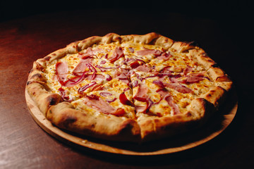 Stock Photo - Fresh delicious Italian pizza  on a dark background