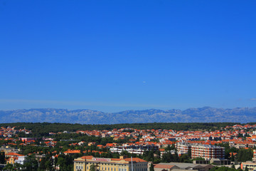 Obraz premium Beautiful view of the rooftops of Zadar from above and the Adriatic Sea. The horizontal landscape of the European city, a clean and beautiful view of the red roofs from a bird's eye view.