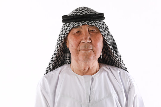 studio portrait of an old Arab man in white clothes on a white background