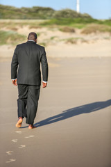Man walking on the beach with no shoes