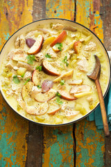 Creamy cider chicken casserole with apples, celery sticks and shallots