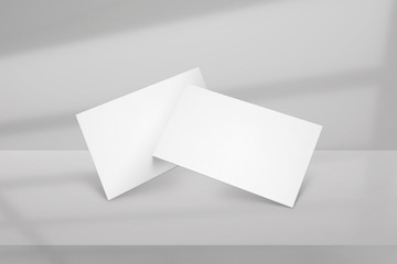 Clean minimal white business card mockup with window shadow and grey background.