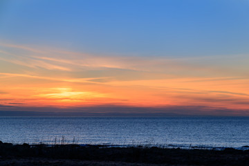 Fototapeta na wymiar Sunset with orange skye in the ocean.