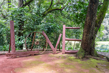Fototapeta na wymiar Tropical garden with the word LOVE written with old wooden boards and cartwheel