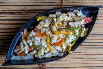 Healthy snack of assorted farm fresh roast vegetables and mushroms in a plate on a rustic table, close up