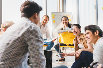 Group asian young modern people in smart casual wear having a brainstorm meeting while sitting in office background. Business presentation, Planning, Strategy, New business development,Startup concept