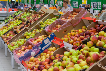 A pile of apples on the counter in the supermarket