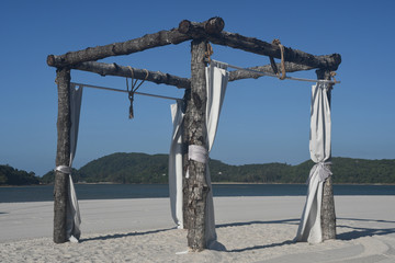 Romantic place on Langkawi beach. Awnings from the sun and wind with white fabrics on white sandy beach Pantai Cenang. Vacation and holidays on Andaman sea Islands, Malaysia.