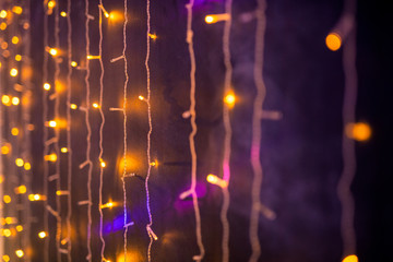 Part of sparkling garlands or lights hanging along wall in night club