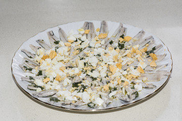 Anchovies in vinegar seasoned with parsley garlic and olive oil with chopped hard-boiled egg