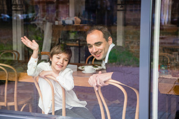 Obraz premium Father and son sitting at the table on a porch