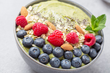 Healthy breakfast bowl: smoothie with banana, raspberry, avocado, blueberry,  almonds, chia seeds and mint. Healthy food concept. Close up