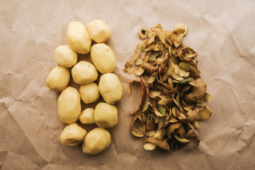 Peeled white potato with peel on craft paper, food, recipe background