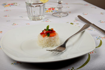 white rice with vegetables on a white plate as a side dish