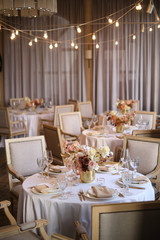 Luxury cozy autumn wedding table decoration in the restaurant. Fresh and dried flowers, roses,...