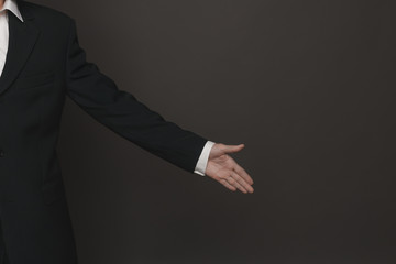 Close up shot of business man's hand ready for handshake. side view close up. Man in formal suit showing on something from up to down direction