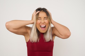 Shocked panic Caucasian girl dressed in stylish clothing holding hands on head and screaming in despair and frustration while being late for plane, her eyes full of terror, mouth dropped open