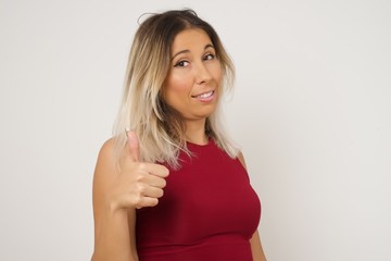 Good job! Portrait of a happy smiling blue eyed young successful woman giving thumb up gesture standing outdoors. Positive human emotion facial expression body language. Funny girl