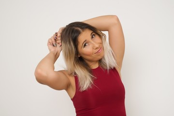 Portrait of beautiful brunette female looks with excitement at camera, keeps hands raised over head notices something unexpected, isolated over gray wall. Lovely woman reacts on sudden news.