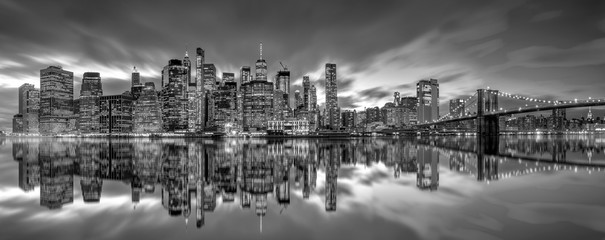 .New York City skyline with skyscrapers at sunset on Brooklyn Bridge black and white version