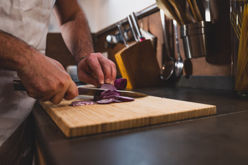 young man cut onion at the home during the lockdown for covid 19
