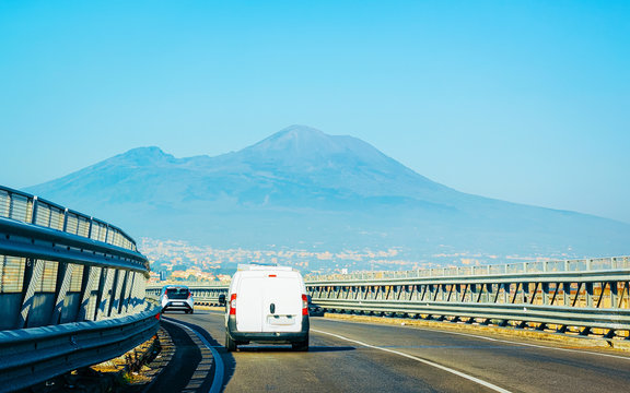 Minivan on road in Italy at Mount Vesuvius mountain reflex