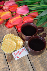 Breakfast. A cup of coffee with a good morning note and tulips. Coffee and waffles for breakfast.