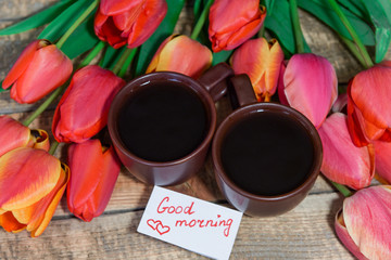 Breakfast. A cup of coffee with a good morning note and tulips. Coffee and waffles for breakfast.