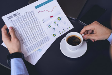 Market researcher scrutinizing a chart in his hand