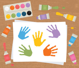 Paint tubes, palette, canvas with colorful handprints. Art therapy.