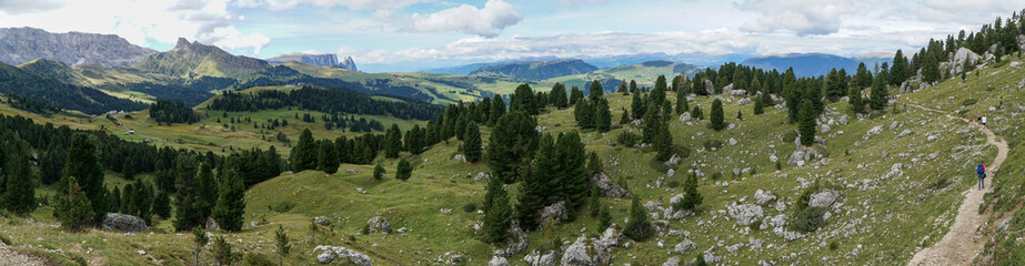 Fototapeta na wymiar Wide and open - panoramic view: Stunning view into the wide and open landscape of Alp de Siusi - Mont Seuc. Gardena Valley, South Tyrol, Italy, Europe.
